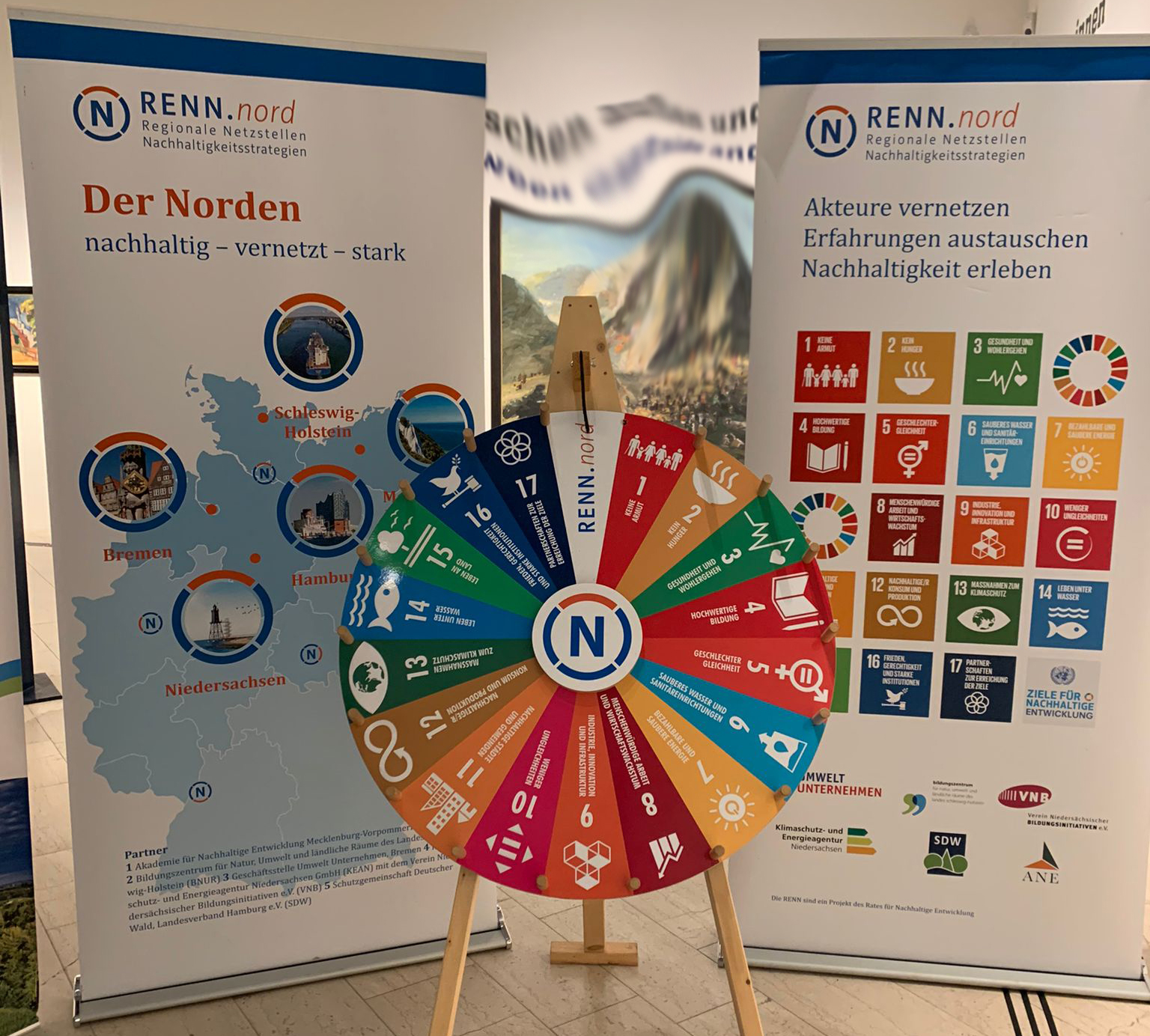 Abbildung des SDG Glücksrades mit 2 Roll-Ups zu RENN.nord